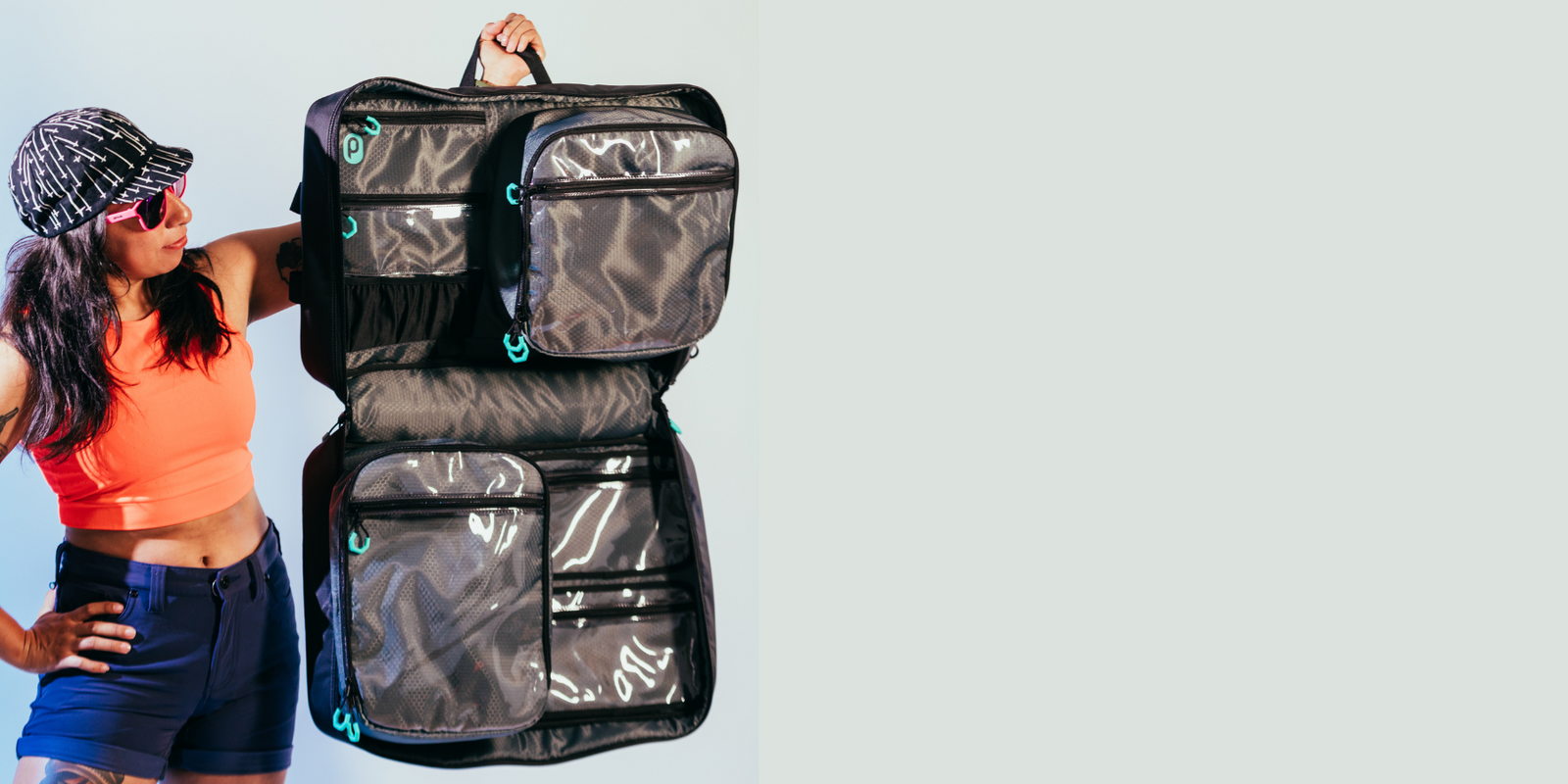 Woman in cycling cap holding open and empty Parc cycling gear bag. 11 pockets including 5 clear pockets are visible.